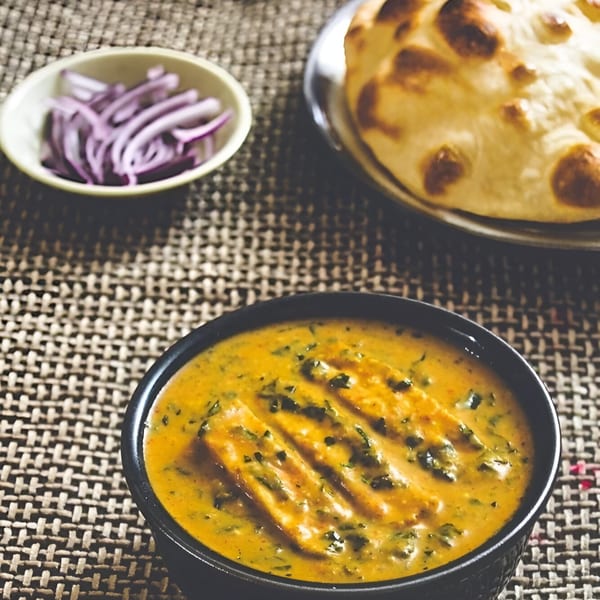 Wok & Sizzle's Indian paneer curry with naan bread and sliced red onions.