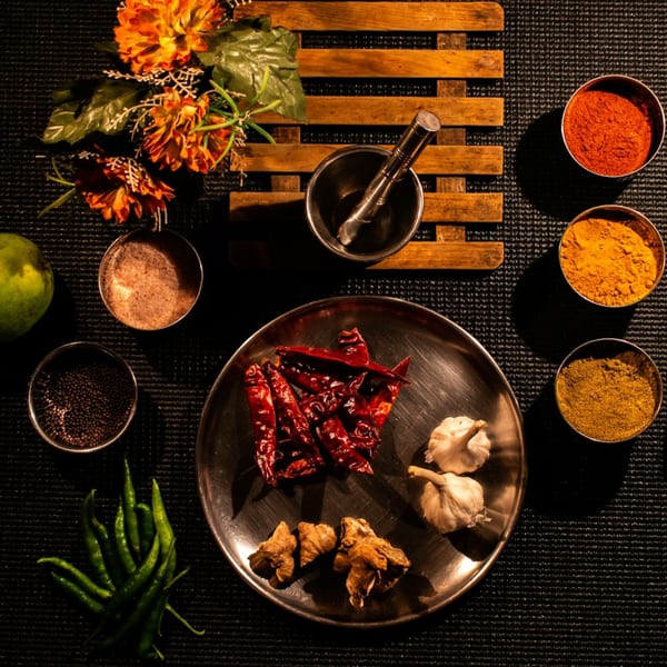 Indian spices and ingredients, including dried chilies, garlic, ginger, and various spice powders.